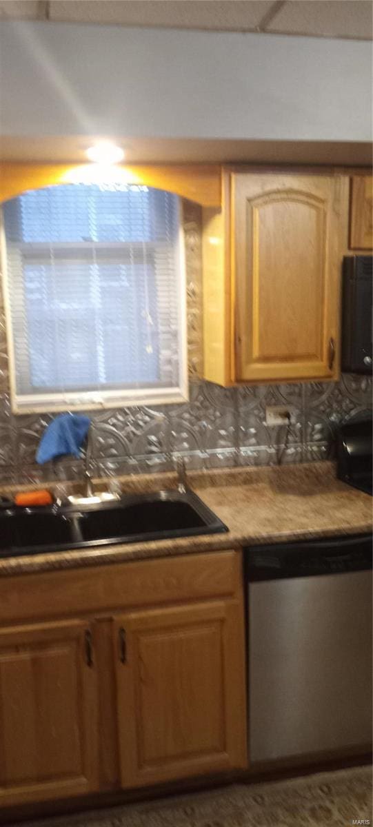 kitchen featuring backsplash, sink, and stainless steel dishwasher