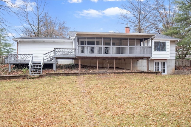 back of house with a lawn, a wooden deck, and a sunroom