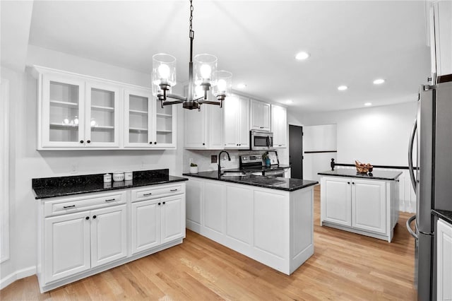 kitchen with sink, white cabinets, light hardwood / wood-style floors, and appliances with stainless steel finishes