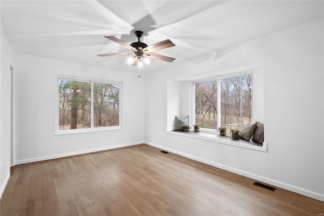 spare room featuring hardwood / wood-style floors, plenty of natural light, and ceiling fan