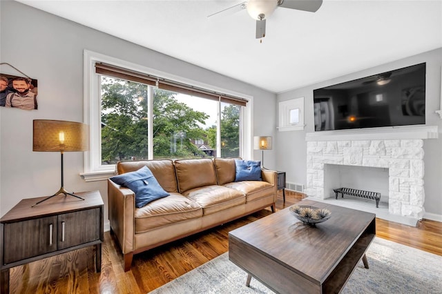 living room with ceiling fan, a fireplace, and hardwood / wood-style floors