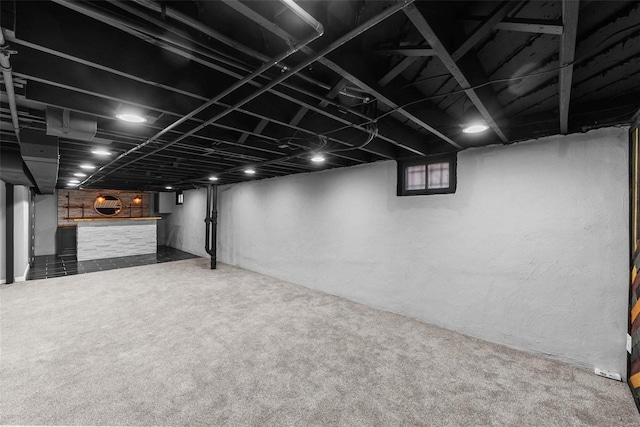 basement featuring carpet flooring and bar area