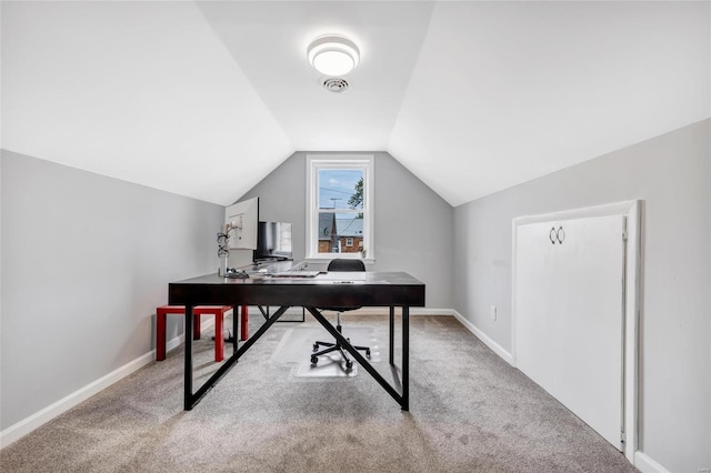 office space with vaulted ceiling and light carpet