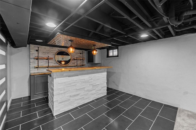 bar featuring dark tile patterned floors and wooden counters