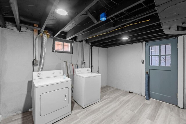 clothes washing area featuring washer and clothes dryer and light hardwood / wood-style floors