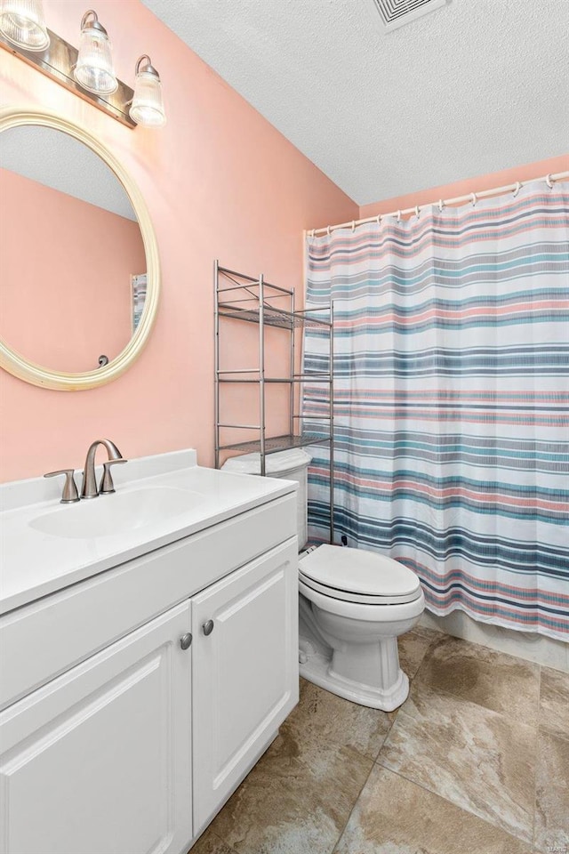 bathroom with vanity, a textured ceiling, toilet, and walk in shower