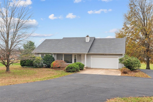 view of front of home featuring a chimney, an attached garage, driveway, roof with shingles, and a front yard