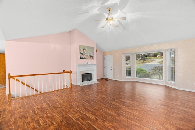unfurnished living room with vaulted ceiling, baseboards, wood finished floors, ceiling fan, and a fireplace