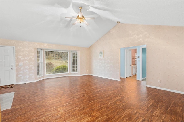 unfurnished living room with wallpapered walls, vaulted ceiling, a ceiling fan, and wood finished floors