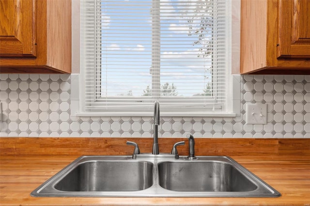 kitchen featuring a sink, brown cabinets, and decorative backsplash