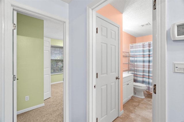 bathroom featuring toilet, vanity, baseboards, curtained shower, and a textured ceiling