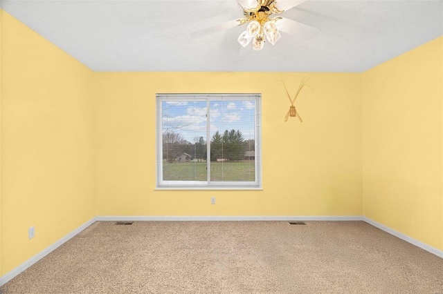spare room with ceiling fan, carpet floors, and baseboards
