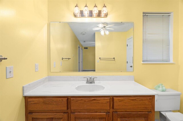 bathroom featuring toilet, vanity, and a ceiling fan