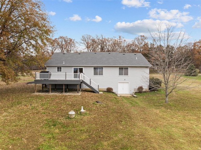 rear view of house featuring a yard, a deck, and stairs