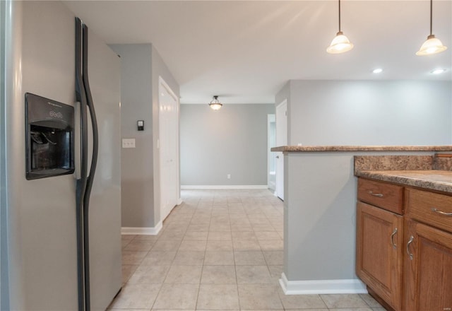 kitchen featuring stainless steel refrigerator with ice dispenser, pendant lighting, and light tile patterned flooring