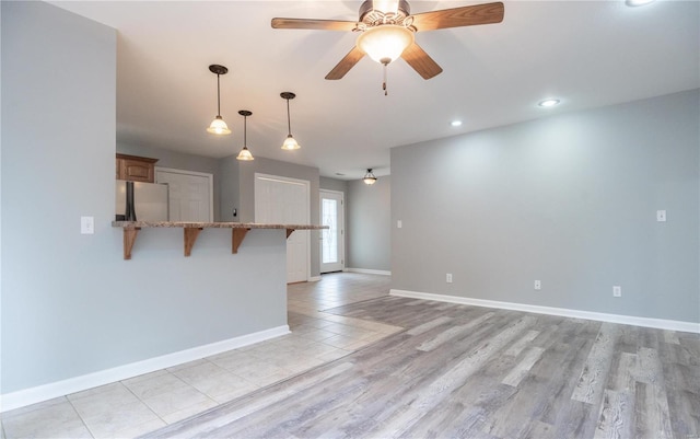 interior space with ceiling fan and light hardwood / wood-style flooring