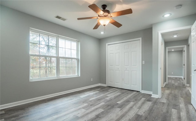 unfurnished bedroom featuring ceiling fan, light hardwood / wood-style flooring, and a closet