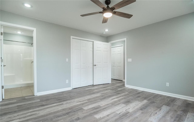 unfurnished bedroom featuring light wood-type flooring, a closet, ceiling fan, and connected bathroom