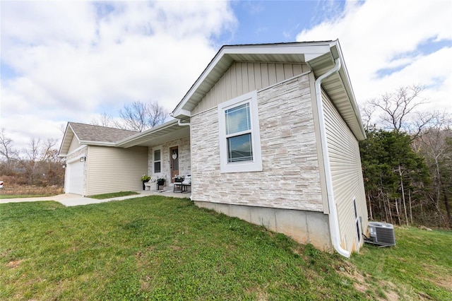 view of property exterior with a yard, central AC unit, and a garage