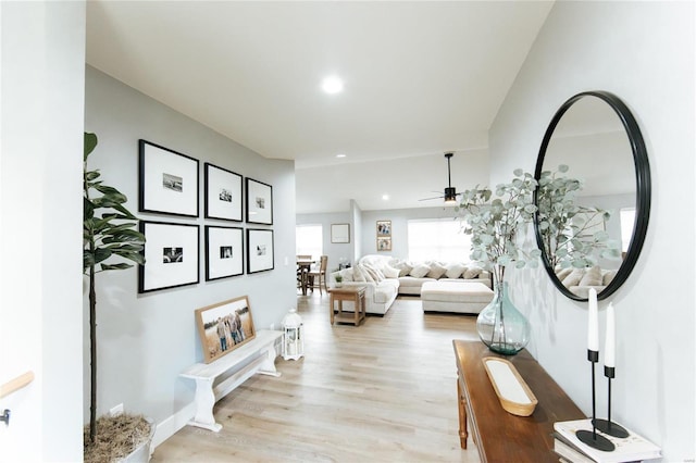 living room featuring light hardwood / wood-style flooring and ceiling fan