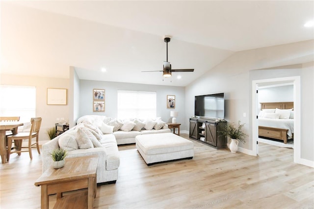 living room with ceiling fan, lofted ceiling, and light hardwood / wood-style flooring