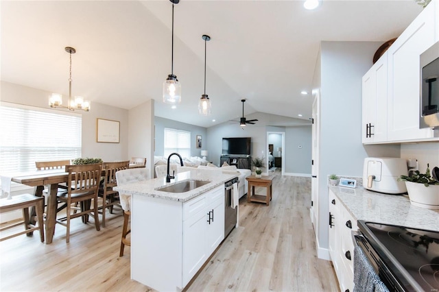 kitchen featuring white cabinetry, sink, hanging light fixtures, and vaulted ceiling