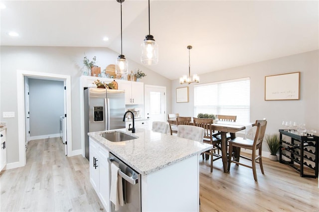 kitchen featuring sink, light hardwood / wood-style flooring, vaulted ceiling, a kitchen island with sink, and white cabinets