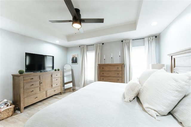 bedroom with ceiling fan and a tray ceiling