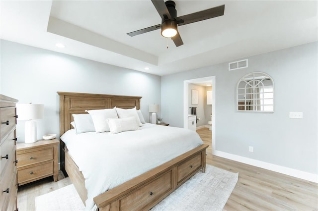 bedroom with ceiling fan, light wood-type flooring, and connected bathroom