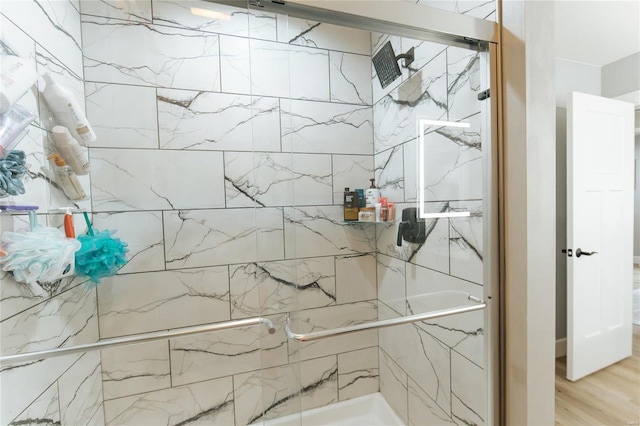 bathroom featuring wood-type flooring and a shower with door