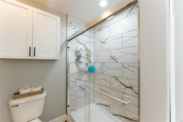 bathroom with toilet and a shower with shower door