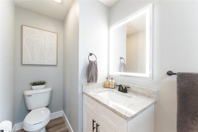 bathroom featuring toilet, vanity, and hardwood / wood-style flooring