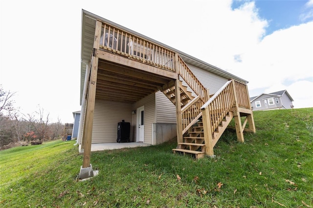 back of property with a wooden deck, a patio area, and a yard