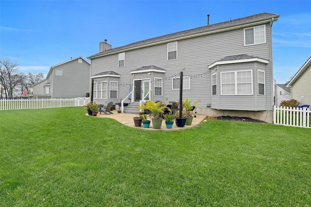 rear view of house featuring a patio and a lawn