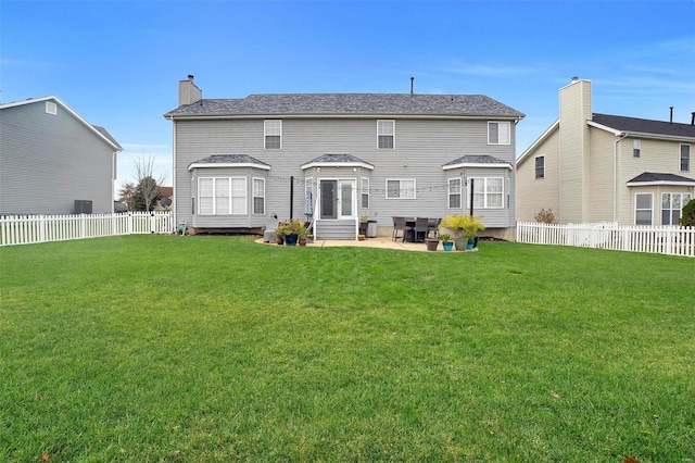 rear view of house with a yard and a patio area