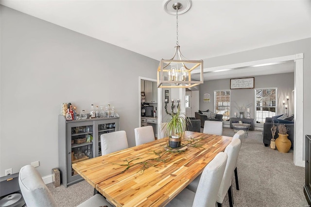 carpeted dining space with an inviting chandelier