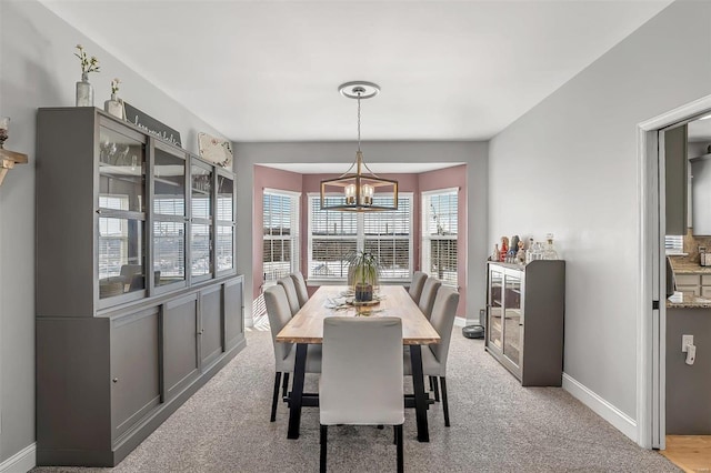 dining area with an inviting chandelier and light carpet