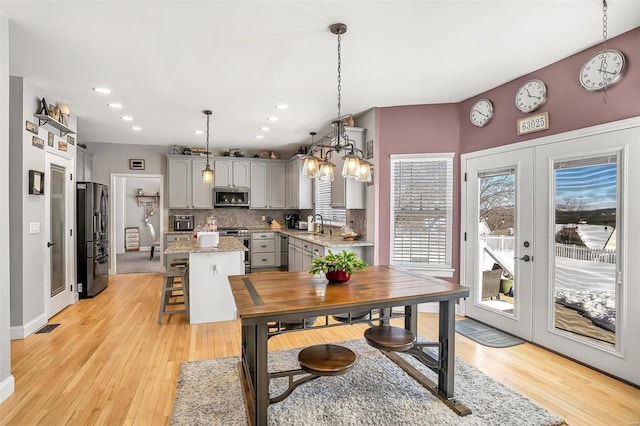 dining area with french doors, light hardwood / wood-style floors, and sink