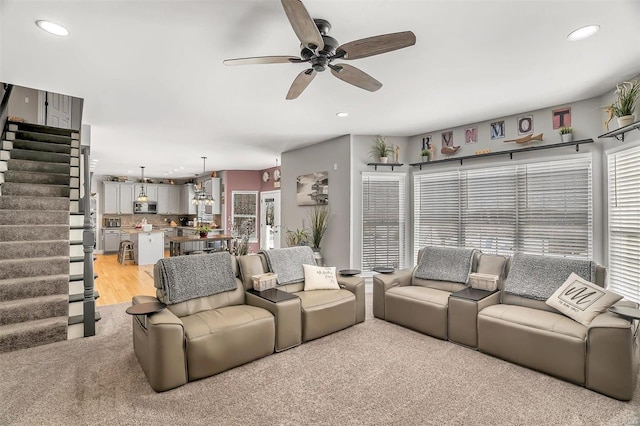 carpeted living room with ceiling fan