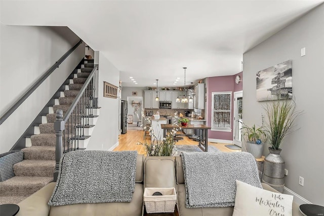 living room featuring light wood-type flooring and a notable chandelier