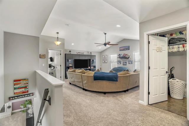 carpeted living room featuring vaulted ceiling and ceiling fan