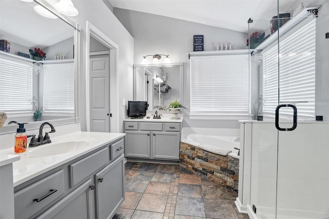 bathroom with vaulted ceiling, independent shower and bath, and vanity