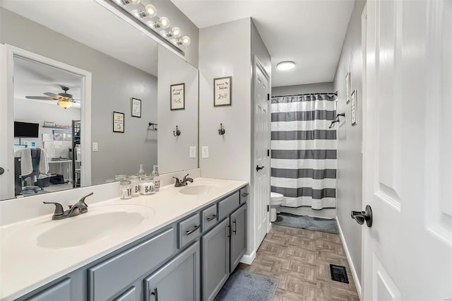 bathroom featuring toilet, ceiling fan, parquet flooring, and vanity