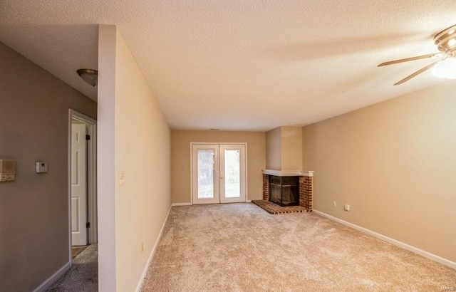 unfurnished living room featuring light carpet, a fireplace, and a textured ceiling