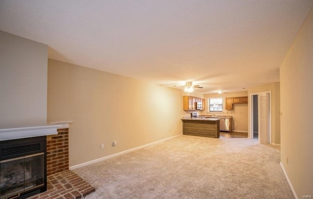 carpeted living room featuring a brick fireplace and ceiling fan