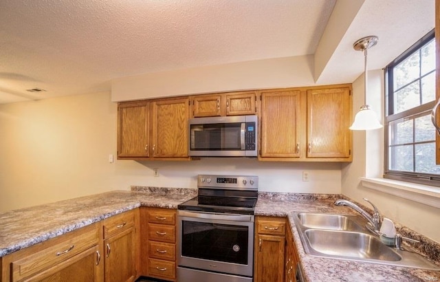 kitchen with a wealth of natural light, sink, stainless steel appliances, and decorative light fixtures