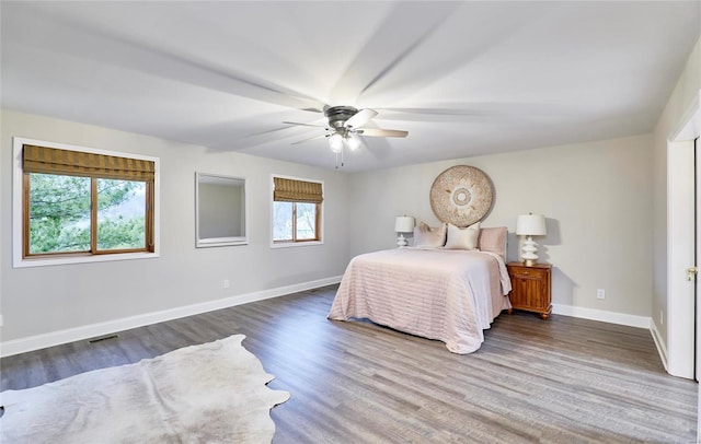 bedroom featuring multiple windows, ceiling fan, and dark wood-type flooring