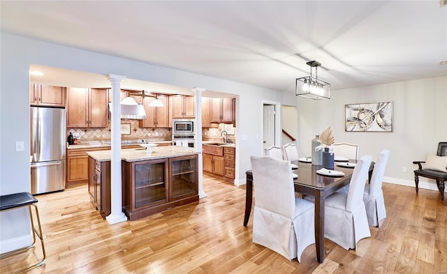 dining space featuring light hardwood / wood-style floors, sink, and a chandelier