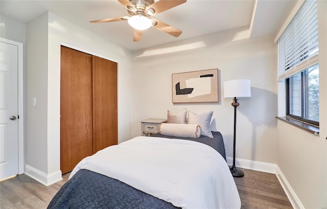 bedroom with a closet, ceiling fan, and dark hardwood / wood-style flooring