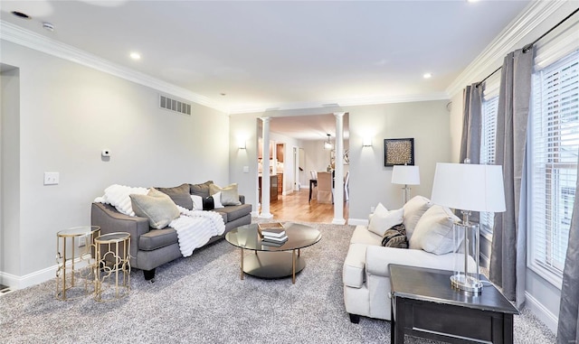 living room with decorative columns, carpet flooring, and ornamental molding